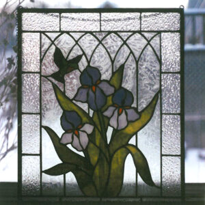 Stained Glass Sun catcher Showing Irises and Hummingbird on frosted background